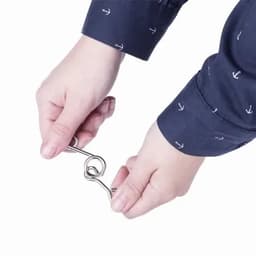A person holding a metal hook with both hands, wearing a navy shirt featuring small white anchor patterns.
