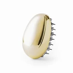 A hairbrush featuring a shiny gold oval design with black bristles. The brush has a sleek, smooth surface.
