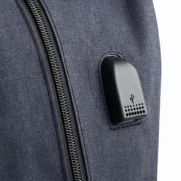 A close-up of a dark blue fabric surface featuring a black attachment with perforations and a logo.