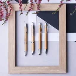 A collection of four pens in a wooden frame, featuring natural wood finishes and silver accents.