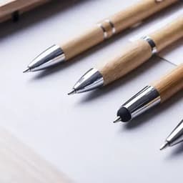 A set of wooden pens with chrome accents, displayed on a sleek surface.