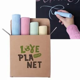 A cardboard box containing four pieces of colourful chalk: pink, yellow, green, and blue, with a hand writing on a chalkboard.