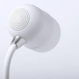 A white earphone with a rounded design and a silver connector. The speaker grille features multiple tiny holes.