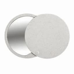 A compact mirror with a speckled grey exterior and a round shape, featuring a reflective surface inside.