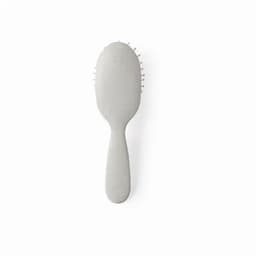 A hairbrush with a smooth, light grey handle and rounded bristles, featuring a minimalist design.