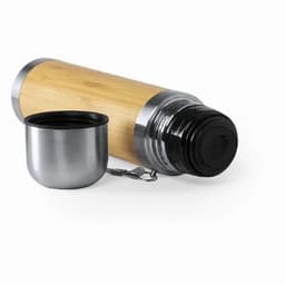 A drink bottle with a bamboo exterior and stainless steel accents, accompanied by a metallic cup.