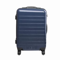 A suitcase in navy blue with a textured surface and four wheels for mobility. It features a handle and a logo.