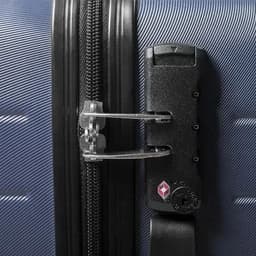 A hard-shell suitcase in navy blue with a black zipper and locking mechanism. It features a logo on the lock.