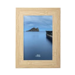 A framed photograph featuring a serene blue landscape with an island and a pier, surrounded by a natural wood frame.