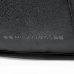 A black fabric bag featuring a subtle logo and textured surface.