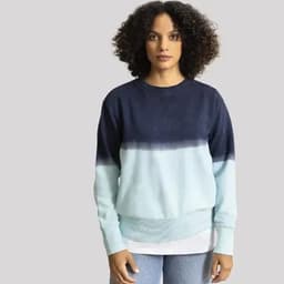 A sweatshirt featuring a gradient design from navy to light blue, worn by a model with curly hair.