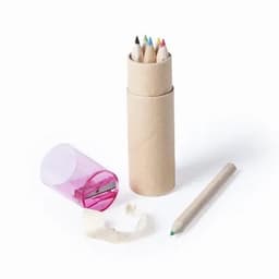 A set of coloured pencils in a cardboard tube, with a pink sharpener and a green pencil lying beside it.