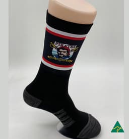 A black sock featuring a graphic design and contrasting red and grey stripes, displayed on a mannequin foot.