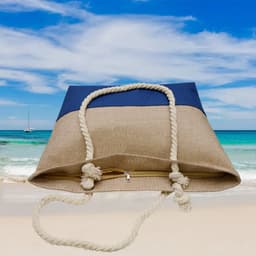 A beach bag in blue and beige with a rope handle, set against a coastal backdrop.