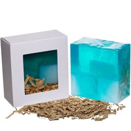 A boxed product featuring a transparent turquoise item and brown shredded paper. The box has a clear window and a logo.