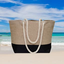 A beach bag featuring a tan and black design, with rope handles, set against a scenic seaside background.