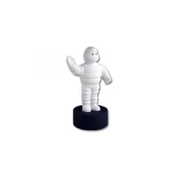 A white stress toy figure with a round black base, resembling a cartoon character, waving cheerfully.