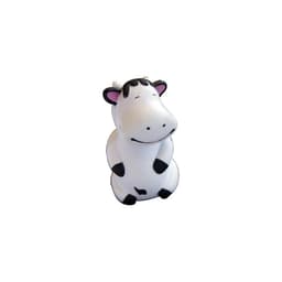 A stress toy featuring a happy, smiling cow in black and white with a cartoonish design. It has a simple, glossy finish.