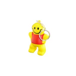 A yellow keyring figure with a smiley face and red shirt, attached to a metal keychain.