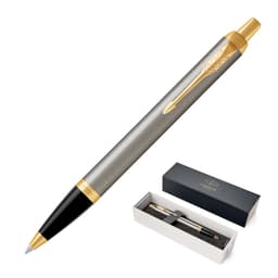 A brushed stainless steel ballpoint pen with gold accents, presented in a black box with branding.