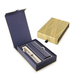 A brushed stainless steel ballpoint pen with a navy case, presented in a stylish gold and navy gift box.