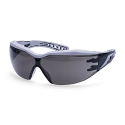 A pair of Dynamic Plus Safety Glasses with a grey frame and dark tinted lenses, featuring a logo on the side.