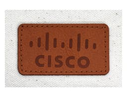 A brown leather patch with a logo and the word "CISCO" on a textured light fabric background.