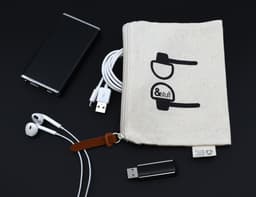 A neutral calico earphone pouch with a logo, surrounded by earphones, USB cables, and a portable charger.