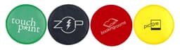 Four circular Frisbees in green, black, red, and yellow, each featuring a different logo or branding element.