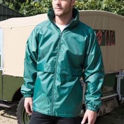 A green rain jacket featuring a high collar and elastic cuffs, modelled by a man outdoors. It has a logo on the chest.