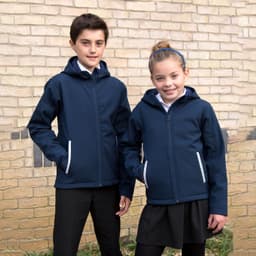 A navy blue softshell jacket with a hood, worn by a boy and girl, featuring zippered pockets and a logo.