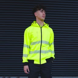 A bright yellow zipped hoodie featuring reflective stripes and a hood, with a logo on the chest.