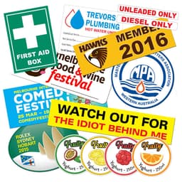 A collection of vinyl stickers in various colours, featuring logos and designs for events and products.