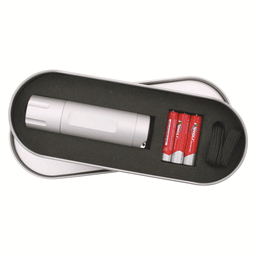 A silver LED torch with batteries, displayed inside a metal tin. The tin has a black inner lining.