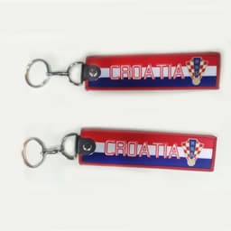 A red and blue woven keyring with the word "CROATIA" and a logo. It has a metal keychain attachment.