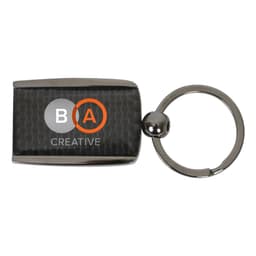 A carbon fibre keychain featuring a rectangular design and a metallic silver ring. It includes a logo.