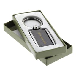 A carbon fibre keychain in a gift box with a metallic keyring and a logo. The box is green and the keychain is dark.