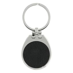 A silver keychain with a round black leather insert and a circular ring for attaching keys.