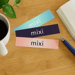 Three glossy paper stickers in teal, navy, and pink, each featuring a logo or branding space.