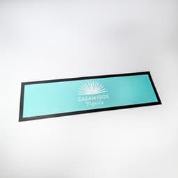 A bar runner featuring a turquoise colour with a black border and a logo design in the centre.