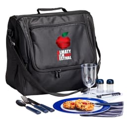A black picnic basket set includes utensils, a drink glass, condiment containers, and a blue plate with food.