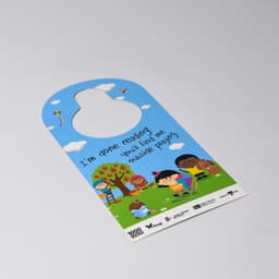 A double-sided door hanger in blue featuring colourful illustrations of children playing and trees. It has a circular cutout at the top.