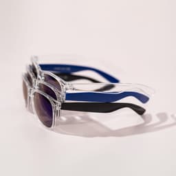 Three pairs of Haze sunglasses, featuring clear frames with purple lenses, and arms in blue and black.