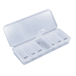 A transparent pill box with separate compartments for each day of the week. It features a clear lid and branding.