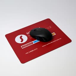 A black optical mouse on a red mouse mat featuring a logo and contact information.