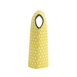 A drink bottle cooler in bright yellow with white polka dots, featuring a cut-out handle and a fitted design.