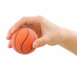 An orange basketball-shaped stress reliever held in a hand, featuring black lines and a textured surface.