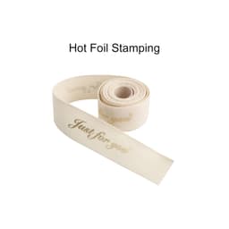 A rolled cotton ribbon in cream featuring gold hot stamping text. It has an elegant and soft appearance.