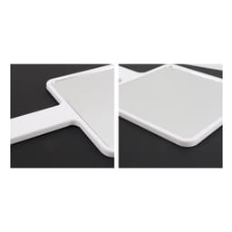 A handheld square mirror with a white frame, shown from two angles on a dark background.