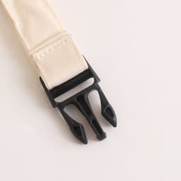 A beige linen bread bag with a black plastic fastening clip. The product features a simple, minimalist design.